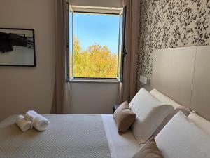 a bedroom with a white bed with a window at Hotel Paradiso 1972 in Schiavonea