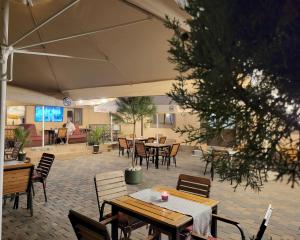 an outdoor patio with tables and chairs and a person in the background at Retro House in Pantelimon