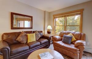 a living room with brown leather furniture and a mirror at CS221 Copper Springs in Copper Mountain