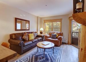 a living room with a leather couch and a table at CS221 Copper Springs in Copper Mountain +36 photos