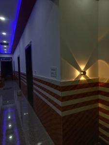 a hallway with a wall with a light on it at Priya Dham in Govardhan