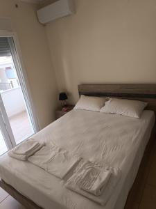 a bed with white sheets and towels on it at Aphroditi Luxury Vila in Chrysi Ammoudia