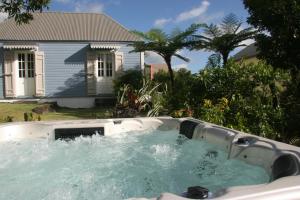 a hot tub in front of a house at Bleu du Sud in Le Tampon