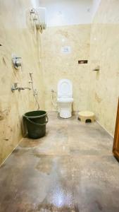 a bathroom with a toilet and a bath tub at The Third Space Varanasi in Rāmnagar +23 photos