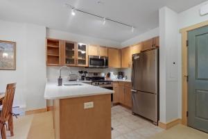 a kitchen with a stainless steel refrigerator and wooden cabinets at CS334 Copper Springs in Copper Mountain