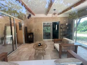 a living room with a couch and a table at Maison récente dans la nature in Roquebrune-sur-Argens