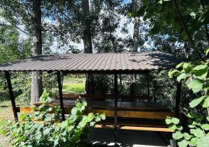 a gazebo with a bench in a park at У Катерини in Dvozhets +4 photos