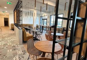 a restaurant with tables and chairs in a room at B&B HOTEL Cap d'Agde Bessan in Bessan