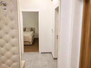 a hallway with a mirror and a bed in a room at Lux Apartman Garden in Paša Bunar