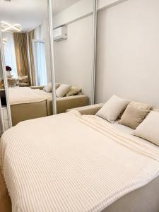 a bedroom with two beds and a mirror at Lux Apartman Garden in Paša Bunar