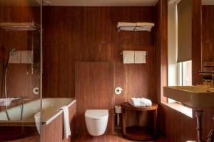 a bathroom with a tub and a toilet and a sink at Hotel The Exchange in Amsterdam