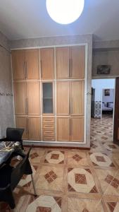 a living room with wooden cabinets and a table at Hotel islam 1 in Tlemcen +1 photo