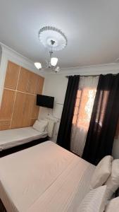 a small room with two beds and a window at Hotel islam 1 in Tlemcen