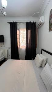 a bedroom with a large white bed with a window at Hotel islam 1 in Tlemcen