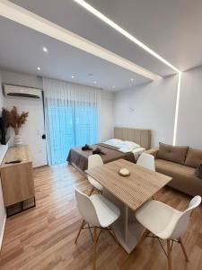 a bedroom with a bed and a table and chairs at Vellora Central Suite in Xanthi