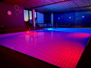 a swimming pool with pink lights on the floor at B&B Apart Hotel Goldener Hahn - Pool & Sauna, Frühstück in Baiersbronn +65 photos