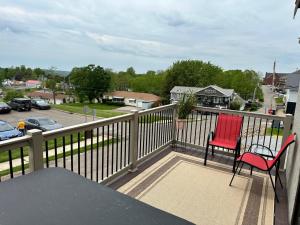 two chairs sitting on the balcony of a house at The Rustic Suite with Hot Tub Romantic Getaway on Main Street in Berlin
