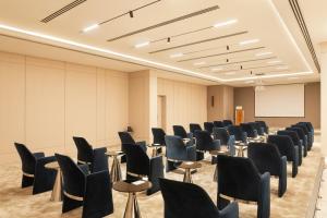 a conference room with chairs and a whiteboard at Grand Bloom Hotel in Baghdād +43 photos