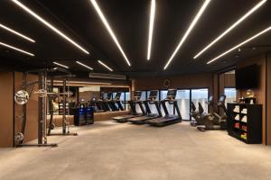 a gym with treadmills and elliptical machines at Grand Bloom Hotel in Baghdād