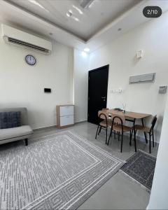 a living room with a table and chairs and a couch at Bowsher 501 in Muscat
