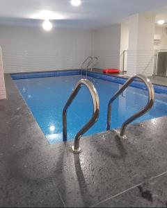 a swimming pool with a metal railing next to it at Bowsher 501 in Muscat