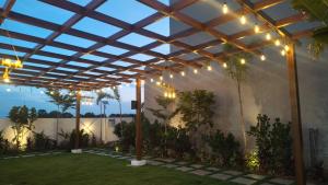 a pergola with lights on a patio at Achala Resorts in Maisaram