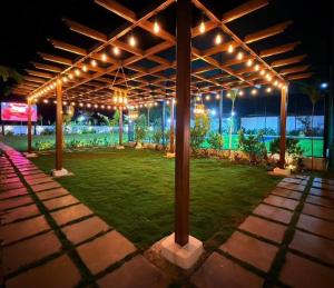 a pavilion with lights on a field of grass at Achala Resorts in Maisaram +6 photos