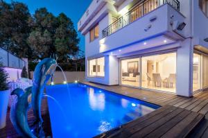 a swimming pool in front of a house at Cosytal Villa in Herzliya