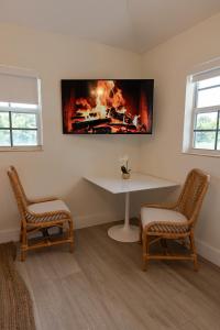 a room with a table and two chairs and a fireplace at Seahorse Beach Bungalows in Fort Pierce