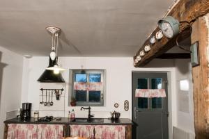 eine Küche mit einer schwarzen Theke und einem Waschbecken in der Unterkunft Chez les Goyp in Cosges
