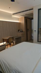 a large white bed in a room with a table at Hotel Grande Court in Kharar