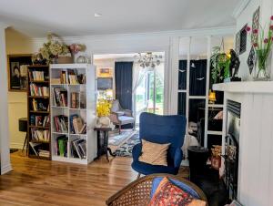 a living room with a blue chair and book shelves at La Tremblante in Mont-Tremblant