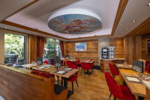 a restaurant with wooden walls and tables and red chairs at Park Hotel Suisse & Spa in Chamonix