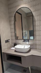 a bathroom with a white sink and a mirror at Hotel Grande Court in Kharar