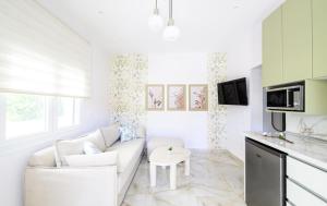 a white living room with a couch and a table at Korina Suites in Perea