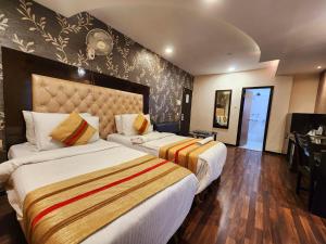 a hotel room with two beds and a desk at Hotel Housez 43 in Kolkata