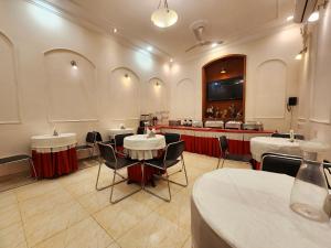 a restaurant with tables and chairs in a room at Hotel Housez 43 in Kolkata