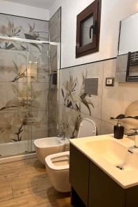 a bathroom with a toilet and a sink and a shower at Civico 44 in Castelmezzano