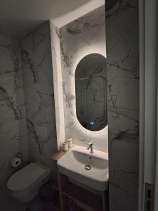 a bathroom with a sink and a toilet and a mirror at Adagio Studio Bar in Bar +27 photos