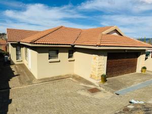 a house with a tile roof and a garage at Kairos Home in Maseru