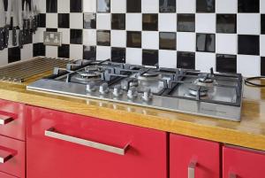a red stove top in a kitchen with black and white tiles at Marina View in Plymouth