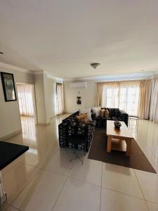 a living room with a couch and a table at Kairos Home in Maseru +5 photos
