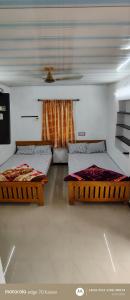 a room with three beds in a room at S K S HOME STAYs in Vālpārai