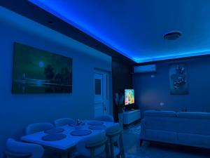 a blue room with a table and a couch at Villa Kalo in Blerimas
