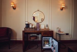 a room with a mirror and a table with a refrigerator at The Goat in Boots in London