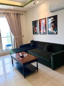 a living room with a green couch and a coffee table at ELYSIUM TOWER Luxury Hotel Apartments Facing Centaurus Mall Islamabad in Islamabad