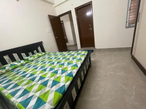 a bedroom with a bed with a quilt on it at Narayana Avenue , kondapur 2 Bhk in Hyderabad