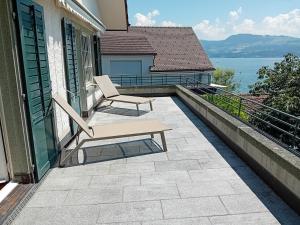 a patio with a bench and a view of the water at Lakefront Villa in Stäfa