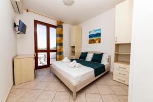 a bedroom with a bed and a tv and a window at Giorni Salentini in Torre Lapillo