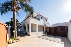 a villa with a palm tree and a driveway at Giorni Salentini in Torre Lapillo